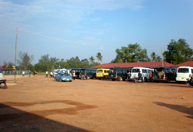 　ターミナルは町の北にある。<br />　赤土の広場で、水たまりがあちこちにできていた。<br />　次々にミニバンやバイクがやって来る。<br />　大型バスが５〜６台停まっている。<br />　そのどれかがシアヌーク行きに違いない。