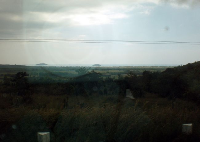 　遠く地平線に海が見えた。<br />　シアヌークビルが近づいたのだ。<br />　その頃になって再び雨が降り始めてしまった。<br />　ぽつりぽつりだった雨が、大降りの雨に変わっていく。<br />　今回の旅、なぜこんなに心配ごとばかり重なってくるのか。<br />　こんな雨の中に降ろされてはかなわない。<br /><br />　ここからしばらく画像はありません。<br />　シアヌークに近づき、気持ちが昂ぶっていたことと、ゲストハウスに到着するまでは、シッチャカメッチャカ焦っていて、カメラを取り出す余裕がなかったからです。