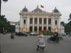フランス統治時代、パリのオペラハウスを模して作られたハノイ版オペラハウス。豪華な建築物の前で、葉笠かぶって天秤担ぐ行商人の姿がベトナムらしい。 