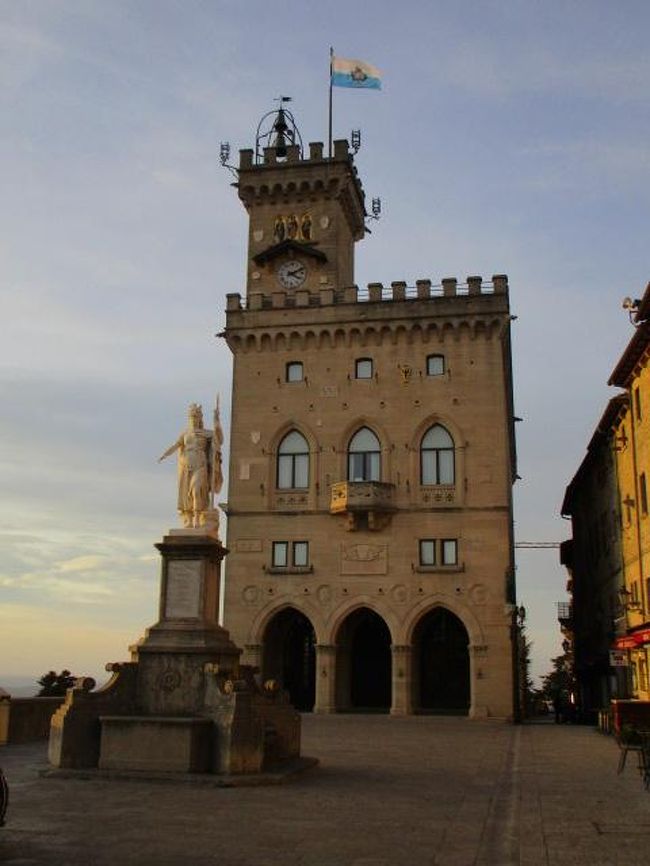 リミニには若干遅れて到着。本当は駅に荷物を預けたかったけどバスの時刻が迫っており１本逃すと滞在時間がタイトになるのでやむを得ず荷物を持ったまま移動。サンマリノは山（ティターノ山）の上に開かれた都市でバスは山をどんどん登っていく。<br />バスターミナル至近の城門から旧市街へ入りリベルタ広場へ。政庁上部に高らかに掲げられたサンマリノ国旗とともに。