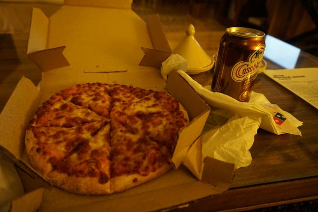 ピザハットは持ち帰りがなかったので、ドミノピザの持ち帰りを。そして、久しぶりのビール!!!写真が小汚くてごめんなさい。<br />ドミノピザ43DH≒600円<br /><br />そして、「ボルジュ・フェズ」を出たところでタクシーを拾おうとするものの、みなさん帰宅時間らしく争奪戦！一人、奥様がすでに乗車しているタクシーが停まってくれ、相乗りで乗せてくれました。しばらく走ると奥様が降り、私たちはブージュルード門で降ろしてもらいました。7DH≒100円。