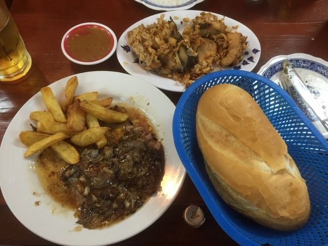 左がビーフステーキとフライドポテト。上がフライドフィッシュ。<br />あとビール、スープ、パンを注文。<br />ステーキはたたいているのかとてもやわらかい。<br />ガーリックが効いたソース。<br />パンやポテトにこそソースをつけて食べると美味しい。<br />でもそれよりもフライドフィッシュのほうが美味しかった。<br />たくさんのニンニクとともに揚げられており、茶色い辛いソースを少しつけて食べると非常に良い。<br />ほかの客の多くはチキンを食べていた。<br />そちらにほうが有名みたい。<br />