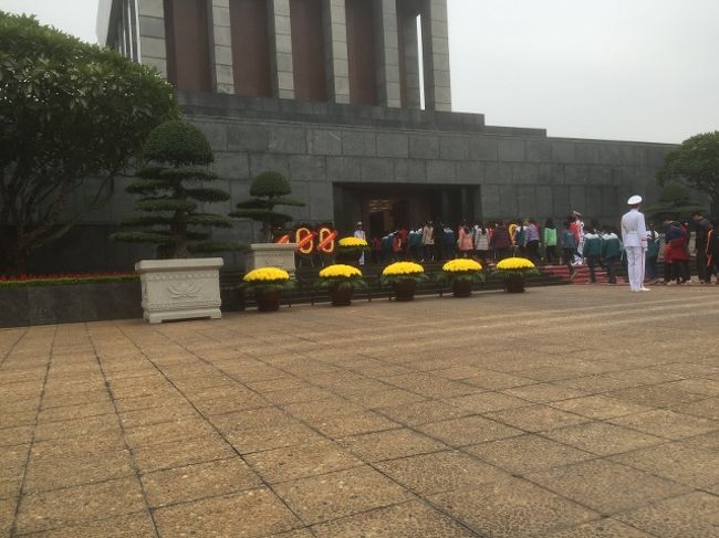 ようやく建物入り口まで来た。<br />衛兵がパチンコ屋の開店時の花みたいなのを持ってきて飾ったり、行進したりしている。<br />中は当然ながら撮影禁止。<br />館内は暑いわけでもないけど、エアコンが良く効いている。<br />保存のためなんでしょう。<br />ホーチミンの棺の周りに4名の衛兵が立っている。<br />寒いし動けないし大変そう。<br />何時間交代かシフトが気になる。