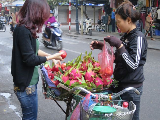 ホテルを出るとそこは旧市街。ハノイ市民の日常が始まっている。<br />この赤い花のような果物は何だろう？