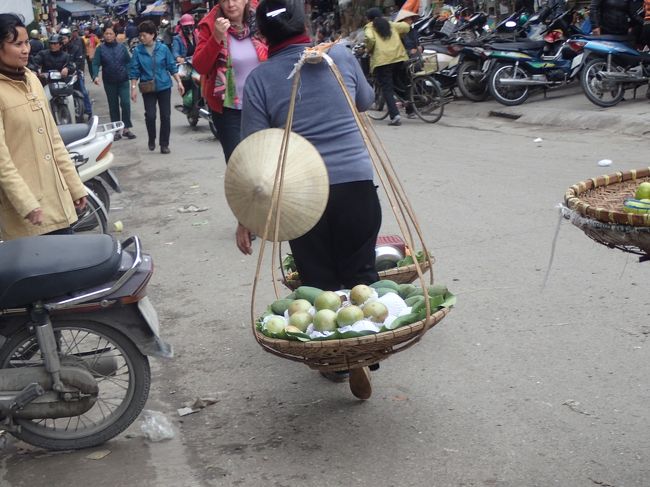 野菜や果物を天秤棒にて担いで。