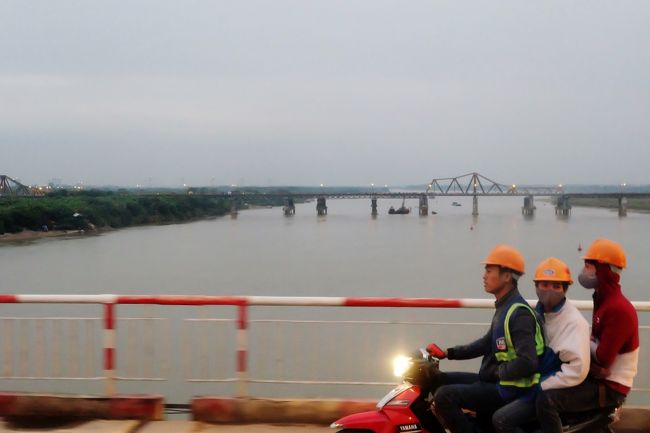 帰る途中、バスから見えたロンビエン橋。<br /><br />手前はバイク3人乗りの片手運転ですね。<br /><br />市内に戻ってホアンキエム湖の南エリアを散策。<br />この辺りは北側の旧市街エリアと違って綺麗なイルミネーションをまとった比較的大きな建物が多いですね。