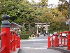 16：40　玉作湯神社
道路に面して車を停めている場所は、駐車場ではなく公園であるとの表示。
でも、駐車場にしか見えないし、皆さん停めてるしなぁ。
道路の向かいには宮橋（恋叶橋）という赤い橋があり、撮影スポットになっていて、カメラを置く台があります。鳥居が入る写真を撮ると恋が叶うんだそうで、まあネタで相方と写真を撮影してみました。