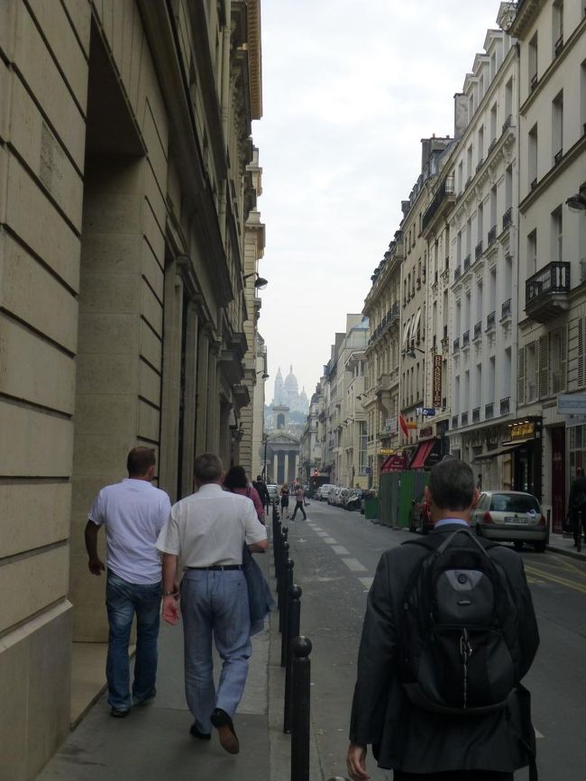 まずは、ノートルダム・ドゥ・ロレット教会を目指す<br /><br />朝早いから、歩ているのはほとんどサクサク歩くサラリーマン<br />立ち止まって地図開き放題<br /><br />そろそろかな?<br />っと、前方に4つの柱、ペディメント（三角破風）、その上にそびえ立つ彫像<br />あったあった、あれだ<br /><br />ん？その後ろに何か薄っすらと・・・蜃気楼？