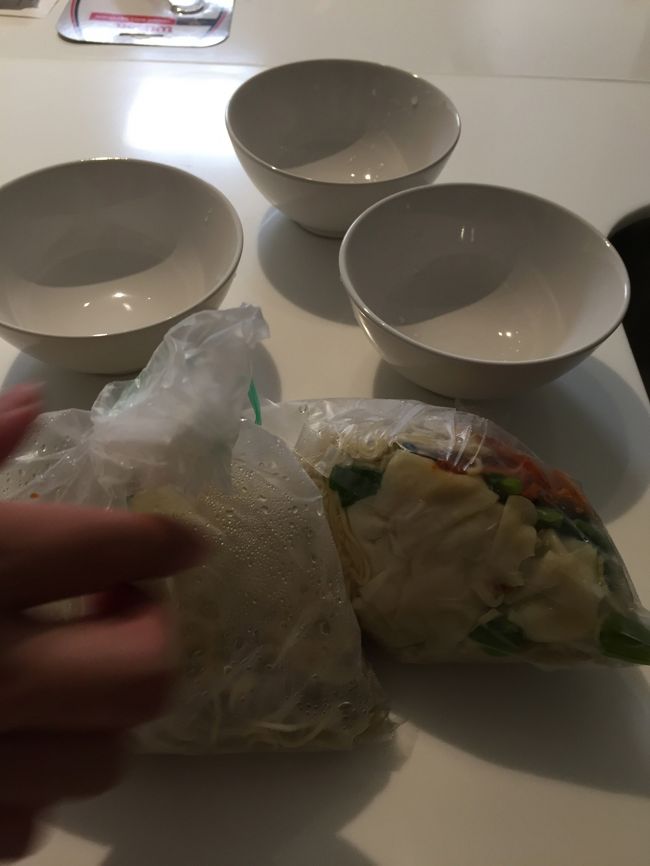 ワンタン・ミー、スープ付きをテイクアウト．日本で言う、金魚すくいの時に金魚を入れてくれる袋に入れて、ぐるぐる巻きにしてテイクアウトにしてくれる．