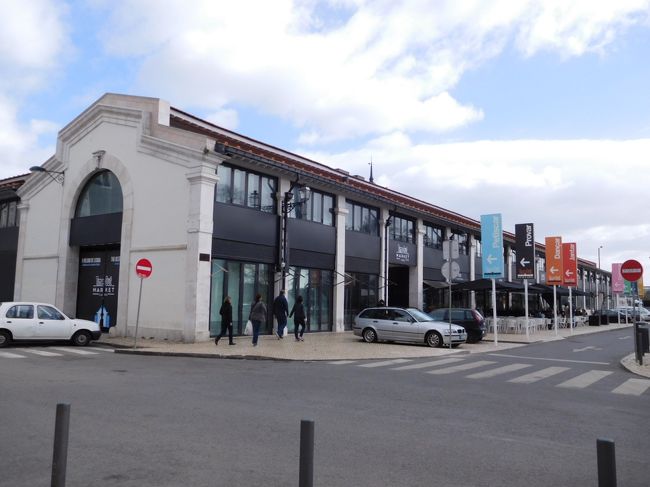 ベレンの塔の近くから１５番の市電でカイス・ド・ソドレまで戻るつもりでした。そしてそのまま戻れれば、まさかのスリに会うこともなかったはず？！。<br />ジェロニモス修道院を過ぎていくつか停留所に止まったあと、突然アナウンスがあり、なぜか全員降ろされてしまいました。<br />ポルトガル語はちんぷんかんぷんなので、待っていればまた別の１５番の市電が来るのかもわからず、他の客に付いて歩いた後、バス停で他の客が乗るのについてバスに乗りました。市電の客が全員乗ろうとするので当然バスはすし詰め状態で、なんとか乗り込みましたが、その時一瞬バッグから意識がそれてしまいました。<br />なんとか掴まるところを見つけ、バッグに意識を戻すとファスナーが開いている。あれ、さっきカメラ出したとき閉め忘れたかと思いつつ、ファスナーを締め、それからはずっとバッグの口を押えていました。<br />後で確認してみると、やっぱりあのわずかの間に小銭入れのポーチをすられていました。まだ入国して間もないこともあり、幸い３ユーロ程度の被害で済みましたが、まさかポルトガル入国初日にスリに遭遇するなんてと、結構ショックでした。<br />札入れとかクレジットカードは紐をつけてバッグに繋いであるので、ちょっとだけ安心なのですが。でもカメラ盗られなくて本当に良かった。<br /><br />話が長くなりましたが、写真はリベイラ市場の外観。