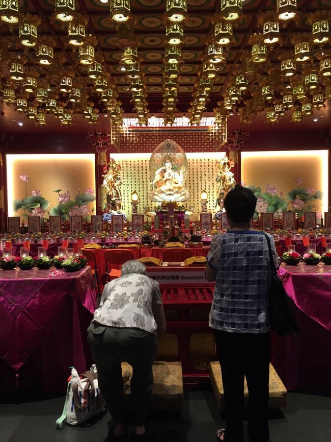 すぐ向かい側にある「ブッタ・トゥース・レリック寺院に入る。有名なお寺じゃないんだけどみんな入っていくので。お釈迦様（？）へのお供え物の供え方が日本と違い面白い。熱心な信者さんの後ろで失礼しました。