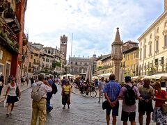 「ジュリエットの家」の前の道（カッペッロ通り）を
数分歩くと、エルベ広場の南東の端に出ます。

エルベ広場（Piazza delle Erbe）に出ました。
長方形の広場に白い屋根のテントを張った店が立ち並んでいます。
古代ローマ時代からこの場所に公共市場があったそうです。

エルベとは ハーブの意味ということで
当初は野菜の市場として出発したらしいのですが
今では肉，花，みやげ物屋などの店が並び
地元の人ばかりではなく観光客にも人気の
スポットとなっています。