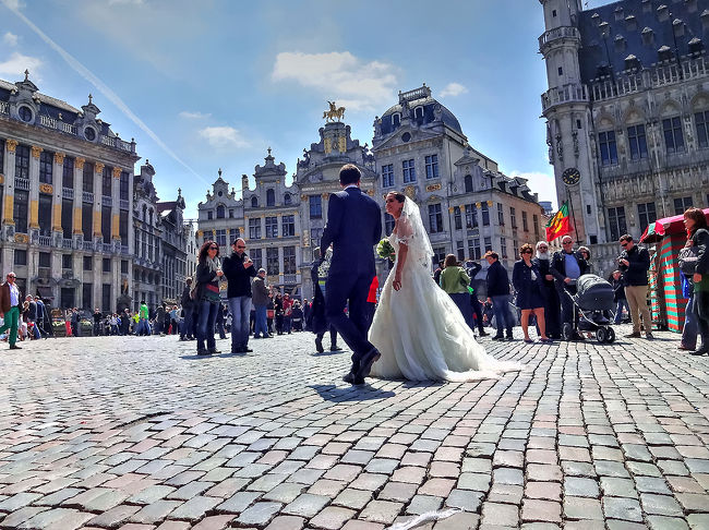 グラン・プラスの石畳を歩く、挙式を済ませた幸せいっぱいのカップル。