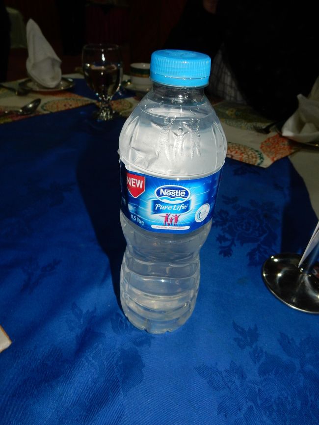 19時に夕食のため集合。<br /><br />昨日注文していた「カフェ・ド・フンザ」のくるみケーキと、アプリコット石鹸が届いていました。<br />その後もメンバーから大量注文を受けたモモさんが手配してくれたのですが、細かい支払いの段取りとか個数の管理とかに、添乗員のKさんが巻き込まれてしまっていて大忙し。<br />仕事増やしてすみません...<br /><br /><br />夕食に出てきたのは、こちらのペットボトルに入った液体。<br />もともとミネラルウォーターのボトルですし水で疑いはなさそうなところですが、実はこれはお酒です。<br /><br />イスラム教で飲酒が禁止されている国ではありますが、戒律の緩いイスマイル派のこの地域では、伝統的に桑の実を使って作る「フンザ・ウォーター」と呼ばれる密造酒が流通しています。<br /><br />当然ながら「密造」ということで大っぴらにはできませんので、こうしてペットボトルなどに入れてカモフラージュし、名前もウォーターなんだそう。<br />「お茶け」みたいなもんですなw<br /><br /><br />モモさんによれば、これを作っていた団体がつい先日摘発されたようで、いまホテルにある在庫がなくなればしばらく入ってこないかも、とのこと(笑)。<br /><br /><br />全員で少しずつ分けて一口飲んでみます。<br />純粋に桑の実の甘さのみで構成されているため、最初の口当たりはかなり大人しめ(わずかな甘みだけが残る)。<br /><br />でも、アルコール度数は25度以上あり、喉ごしはかなりきつい感じ。<br />トルコのラクみたいな感じで、少しずつワンショットで飲むか、何かで割ってとかしないと(そんなに酒が強くない)自分にはややきつめに感じます。<br /><br />調子に乗っていたら悪酔いしそうだな、と思ったので、夕食時は軽めに2杯でストップ。<br />といいつつ、あまった分をナイトキャップとしてもらって帰ったんですけどね(笑)。