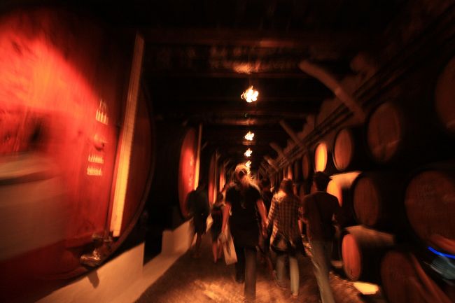 時間になったので、ツアー開始。サンデマンのロゴの、マスクオブゾロみたいな格好をしたお姉さんが案内してくれます（笑）<br />中の写真を何枚も撮ったけど、暗いところの写真が下手すぎて、これが唯一まだマシな写真…<br />ちなみに倉庫は見学用かと思いきや、普通に通常使われている倉庫とのこと。こんなに人が出入りしても大丈夫なんだろうか？