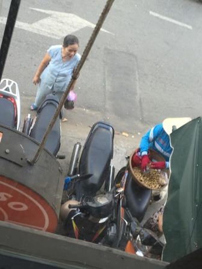 ２Ｆの席で休憩していると、バイクで豆を売っている人とそれを覗いている<br />ご婦人が見えます。