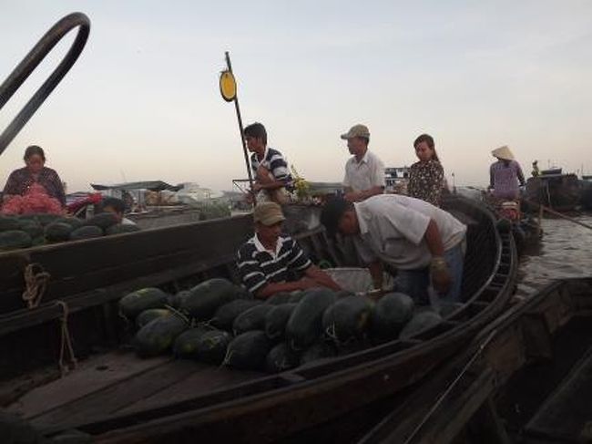 卸と思われる大型の船に乗っている野菜や果物が、購買人（小売）の小さな船に船伝いに運ばれます。