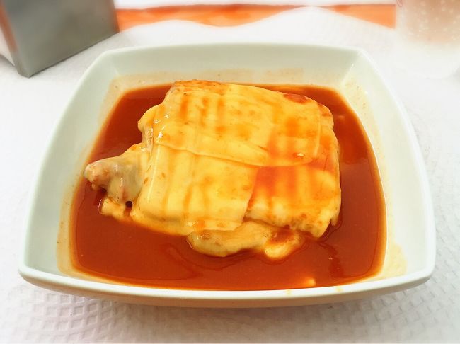 こちらがポルトのB級グルメ、フランセジーニャ！これが美味しくて美味しくて！ポルトでは大抵どこのお店でも（カフェでもレストランでも）、ハズレがない料理です。<br />薄切りの食パンの間に、ハムやらチョリソー、薄切りのお肉などが挟んであって、上にチーズを乗せて焼いたもの。ちょっとピリッとするソースがひたひたで、ジャンキーだけど本当に美味しいおすすめグルメ。これは日本でも食べたい…。<br />友達はちなみにずっとビール飲んでました。ここまでのごはん時すべて！（笑）