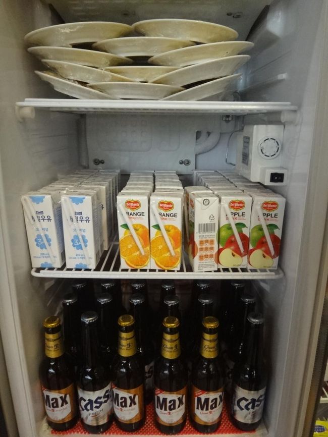 韓国・金浦国際空港のプライオリティパスで入れるラウンジ<br /><br />カード会社ラウンジ『エアラウンジ 休（HUE）』のドリンクコーナーの写真。<br /><br />紙パックに入ったジュースと韓国ビール(瓶)が2種類あります。<br />