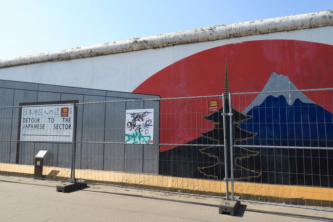 オスト駅からベルリンの壁を見にイーストサイドギャラリーへ。<br /><br />日本をモチーフにした絵。<br />絵に落書きされる事が多いせいで壁の前にはフェンスが。<br /><br />壁の長さは1.3?。この日も一日快晴で暑い！