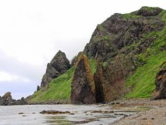 そして、メノウ浜の先には地蔵岩と呼ばれる不思議な岩がある。

大岩がパカっと二つに割れ、まるでお地蔵さまが両の掌を合わせたかのように見えるので、地蔵岩という名前がついたという事だ。

24年前に礼文島で8時間コースを歩いた時、宇遠内からの海岸線をひたすら歩き、この地蔵岩が見えた時が最高のクライマックスで、地蔵岩の間を抜ければあと1時間でYHに辿り着ける…という思い出の場所だった。

しかし、現在はこの地蔵岩のある海岸線は歩くことは出来ない。
落石の危険があり、立ち入り禁止区域となっている。
そんな思い出の岩を少し離れた場所から眺める。