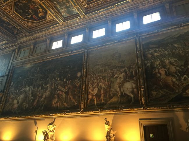 レオナルド・ダ・ヴィンチの絵の上にヴァザーリが新しく絵を描いたので、今でもその絵の下にレオナルド・ダ・ヴィンチの絵が隠されていると言われています。<br /><br />それを示すかのように、フレスコ画の上部でフィレンツェ兵士が掲げている緑色の軍旗のところに、"Cerca trova"（「探せ、さすれば見つかる」）というヴァザーリの文字が記されており、これがヒントではないかと現代の研究者は推測しています。<br /><br />