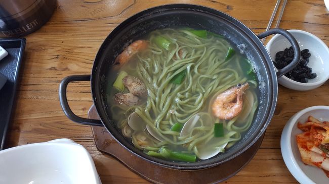 それとカルグクスも注文。<br />麺が緑になってる！なんか練り込まれてるみたい。<br />貝が入っていて、お出汁がうまーーー！<br />朝からお腹パンパン！