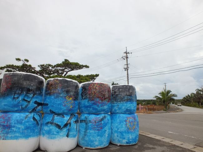 まだ夕食まで時間があります。<br />幹線道路沿いにある、展望台まで出かけます。歩いて5分ほどの場所ですが。<br /><br />集落の入口に明石エイサーの告知準備をしているようですが、まだペンキ塗りかけです。<br />これ、牛が食べる藁を包んだものに書かれています。