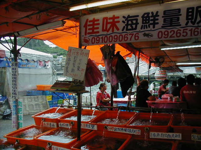 鴬歌と野柳を行く 2005/05/06<br /><br />高速に乗って、目的地「野柳」へ。お腹が空いたので、海岸通りにある海鮮料理店に入る。店と言っても、仮テントに机と椅子を置いてあるだけだが、水槽には新鮮な魚介類がいた。早速、水槽中の食材を選ぶ。私は食べるのも好きだが、見るのも大好きである。貝類も１０種類くらいいて、勿論、蛤もあった。蟹もワタリガニを含めて数種、蝦、伊勢海老もいた。魚は台湾で一番人気のスーバン（石班）を含めて、これもまた数種。一通り見た所で、ワタリガニ、石班、蝦、蛤、サメ、巻貝をチョイスしたが、どれも新鮮で美味かった。全部で１４８０元（４５００円）だったのは、びっくりするほど安かった。<br />