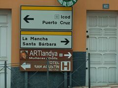 これから行こうとしているARTlandya DollMuseumは人形博物館。
欧州人オーナーご夫妻が個人の邸宅敷地内に造った博物館に、世界に数体しかない人形も取り混ぜて、そのコレクションを公開しています。

テネリフェ島北西岸のイコー・デ・ロス・ビノスという街にあって、この画像のように随所に道案内の標識が出ているんですが、
「じゃ、イコー・デ・ロス・ビノスの街の中心部から歩いて行けるのね！」と思った方は要注意。

この街は、テイデ山北麓が大西洋にドッと落ち込む斜面にあるため…、