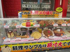 通天閣の付近にはたくさん食べ物屋さんがありました。
ちょうどお昼時間になってきたのので、
串カツ屋さんには行列ができているお店もあったし、
すでにビールと串カツで一杯している方々も結構いました。

↑の写真は目立っていた料理のサンプルの写真です。
メガ盛りですか、すごいですよね〜！

ちょっとプリンとか実物見てみたいですね。
この大きさに作ってうまく中まで固められるのでしょうかね？