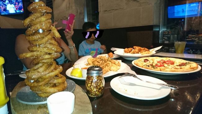 お腹ペコペコだったので、ガッツリとオーダー！もちろん、ハッピーアワーメニューです。<br /><br />うまい具合にオニオンリングタワーでママが隠れてます。。。<br />ピザ、オニオンリングタワー、チキン、カラマリフライ！<br />なんてジャンキーな組み合わせなんでしょうか〜…<br /><br />タロさんは、ピザやチキンを食べました。<br />広いテーブルのソファ席だったので、日本から持参したミニカー走らせたり、となりの席の外国人の男の子(２〜３歳)とソファ越しにジャレ合って遊んでいました。<br /><br />子どもってスゴイ！言葉や人種の壁なんて全然！関係なくスッと仲良くなってました。<br /><br />パパは地ビール系を、ママはフルーツビール系を美味しくいただいて…トータル$６５くらいだったと思います。安〜！