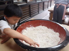 次に向かったのは、そば打ち体験のできるごっつおさん亭。
すず丸はもちろん、すず母もそば打ちは初めての体験でしたが、ちゃんと指導の人がついてくれ、難しいところはやってくれるので、初めてでもそれなりのそばができます。
すず母は、愛用のデジカメを落として修理中のため、防水防塵仕様の予備カメラを持っていったのですが、手に粉がついている状態でそば打ち体験を撮影するのに役に立ちました。