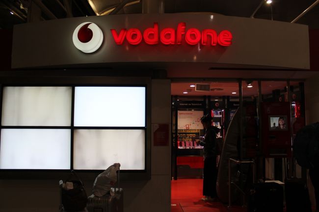 到着ロビーを出て右に行くとvodafoneがあった。前には4名ほど並んでいた。一瞬待つのをためらったが、ここは店員が設定してくれるとの情報だったので並ぶことにした。20分は待ったであろう、私は最後の客だった。<br />店員に｢データオンリー、シムカードプリーズ｣と言うと各ＧＢ別に料金を書いて提示してくれた。容量を迷い、７日間滞在する事を言うと、それなら一番少ない1GBで大丈夫だと言うので1GB15ﾕｰﾛのﾌﾟﾗﾝにした。
