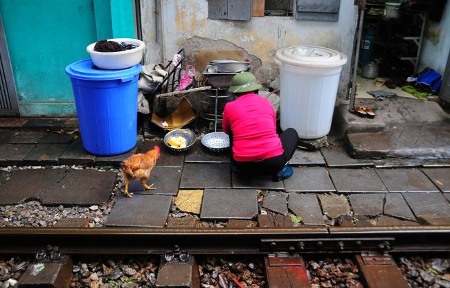 お母さんは炊事の途中。<br />帽子がかわいい。<br />そして付き添いのニワトリ。<br />彼女らにとっては普通の生活の場です。