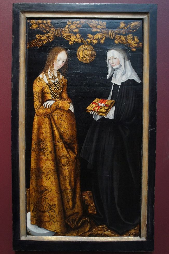 ルーカス・クラナッハ「聖クリスティーナとオッティリア」（ロンドン・ナショナル・ギャラリー）<br />ボルセーナの聖クリスティーナは湖に放り込まれたずぶ濡れの姿で石臼の上に立っています。キリスト教が禁止されていた時代に啓示をうけたクリスティーナはキリスト教に帰依します。反対された父王によって幽閉され、拷問され、ボルセーナ湖に沈められ、最後は矢で射られ殉教します。