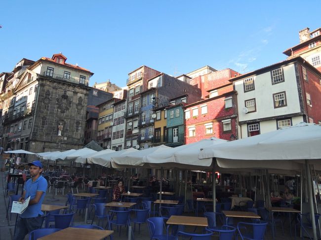 川沿いはレストランやお土産屋さんでいっぱいです。<br />こちらはリベイラ広場、夕食にはまだ早い時間なので、<br />お客はまばらですが、陽が落ちる頃には観光客で賑わうことでしょう。<br /><br />あれ、左の建物の真ん中に不思議なお人形のような物が・・・？<br />