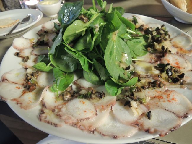 ２品目は、タコのカルパッチョ！<br /><br />これも美味しいィィィイイイ！<br />偶然入ったレストランにしては、なに、この美味しさは！！！<br />今まで食べた事がない感じのカルパッチョです。<br />ワイルドルッコラてんこ盛りも最高！<br /><br />しばらくすると、頭にバンダナを巻き白いコック服を着た小柄なおじさんが店内に目をやりながらブラブラ・・・。<br />「楽しんでる～？」みたいなそぶり。<br />もしかして「あなたがシェフ～？」と聞いたら、「Yes!」<br />思わず、拍手してしまいましたぁ。<br /><br />ワイン・ボトル１本、お料理２品、パンで、40.50ユーロ（約￥4,600）<br />駅から近い街中なので、ちょっと高めかも。