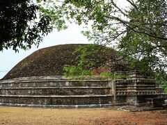 脇道の階段を昇ったところで姿を現したのは、日本の円墳のようなこんもりした仏塔、“カンタカ・チェーティヤ”（Kanthka Cetiya）。

高さ12ｍ、周囲の長さは130ｍもあるというこの仏塔は、紀元前２世紀のラージャ・ティッサ王（Lajjitissa、在位：BC119-BC109年）の時代に造られたもの。

１１世紀に南インドのチョーラ朝の攻撃を受け、アヌラーダプラの古代シンハラ王朝が滅亡した後は、このミヒンタレーも放棄され、人が住まない地となります。

この地にあった仏塔や僧院など古代の建物群はジャングルの底になって長い眠りにつくこととなり、ようやく発見されて再び人々の信仰の対象となったのは、なんと２０世紀になってからのこと。

それでも、このカンタカ・チェーティヤは完全に修復されておらず、聖地とはいえ、この場所を訪れる巡礼者は少ない様子。

今は失われてしまいましたが、創建当時は中央部分から空に向かって伸びる塔があったのでしょうか。
