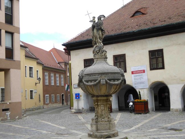 教会前に広場には、18世紀に造られたマリアの泉。<br />十字架を手に持ったキリストとマリアの聖母子像。