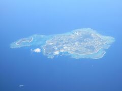飛行機が向きを変えた途端、急に目に飛び込んできた島影。
もう沖縄本島のすぐ近くまで来ていたことに気づいて、サンゴ礁の海の色にテンションが上がる。