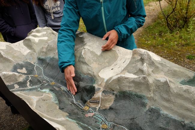 模型を使って色々説明してくださるガイドさん<br />今いるところと山を挟んで反対側が明日行くところ。<br /><br />私のメモには<br />・タカカウ滝の水はデイリー氷河からの解け水<br />・ボウ川 ハドソン湾に流れ込む<br />・2500キロ<br />・鮭はこない<br />と謎の暗号（一部解読可）が書いてありますが、きっとここで聞いたのでしょう。