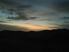 　初めは４WDで、がたがた道を１時間。その後ラクダに乗り換え30分ほど。なだらかな坂道を登ったり下りたりしました。かなり揺れます。薄いジャージーの手袋をしていましたが、しっかり握っていたせいで生地が薄くなり、ホテルに戻ってから捨てました。恥骨が痛いです。

　まだ薄暗いです。思ったほどではないですが、ダウンを着ないと寒いです。
着いてしばらく待ちます。ラクダの先導者というか、ガイドというか、イケメンのお兄さんたちと、写真を撮ったり、片言の英語でおしゃべりしたりして、日の出を待ちました。