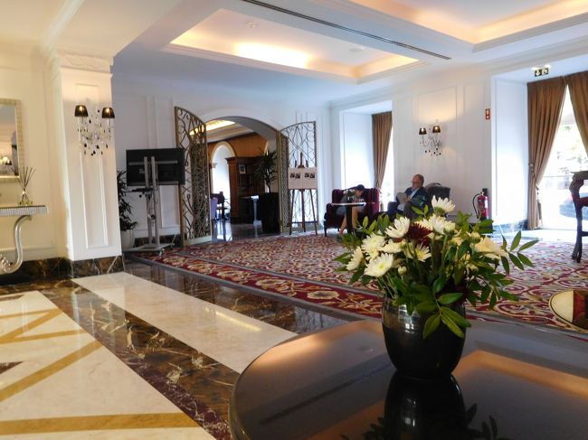 ホテル正面を入って右の奥の、銀行のカウンターのような、３～４席デスクがあるところがチェックイン、チェックアウトする場所。カウンターには女性スタッフがひとりいるだけで、座って話をしていたお客さんが終わってから私もチェックイン。最近のホテルはこういうふうになってきてるのかしら（コインブラのホテルもそうだった）<br /><br />椅子に座って、チェックインすると、その若い女性スタッフは、すぐに名前をフルネームでずっと呼んでくれ、嬉し恥ずかしな気分。<br />朝の９時前では部屋はまだ用意できてなく、荷物を預かってもらい、午後に帰ってきますと、街へ出る。<br /><br />ホテルのこのロビー、広くて静か、綺麗で落ち着いてる。<br />秋はやはり菊の出番か・・日本だと洋花を飾るようなところでも、菊の花がきれいに生けられている。