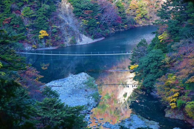 紅葉の「夢の吊橋」を渡る人たち<br /><br />川面に渡る人と紅葉が映っています。<br />