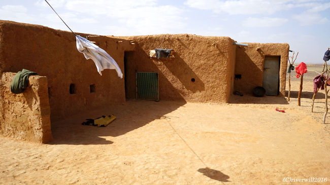 ノマドファミリー8人家族が棲む母屋。土とその辺から拾ってきたトタン板などからできています。<br /><br />一応、自家発電設備はありましたが、豆電球レベルしか灯せないようです。<br /><br />また、彼らは基本的に夜は外で寝ていました。外敵もいないし、外の方が涼しいんですよね。