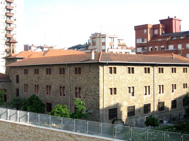 平成18年5月16日（火）ビルバオ　街並み風景<br /><br />　共和国軍によって鎮圧された小規模な反乱がビルバオで起こったことでスペイン内戦が始まった。1936年8月31日には初の爆撃を受け、翌月にはフランコ軍と提携したドイツ軍による爆撃を受けた。ビルバオは防衛のために要塞化されたが、1937年5月にはフランシスコ・フランコの国民党軍によって包囲され、6月19日に陥落した。プッツ将校はネルビオン川に架かるすべての橋の破壊を命じ、第5旅団の部隊が町を略奪した。内戦中にはバスク自治政府が設立され、ホセ・アントニオ・アギーレが初代政府首班となった。<br />　スペイン内戦が終結すると、ビルバオは再び産業的な発展期に戻り、人口は着実に増加した。1940年代には都市が再建され、何本かの橋が建設された。1948年にはビルバオ空港に初の民間商業機が着陸した。<br />　1950年代には鉄鋼業界が復活し、住宅の需要が供給を上回ると、労働者は丘の上にスラム街を構築した。この混沌とした環境で、1959年7月31日にはバスク民族主義党(PNV)の分派としてバスク祖国と自由(ETA)がビルバオに設立された。フランコ独裁政権の終焉と立憲君主制への移行後、スペインの変化の過程でビルバオは民主的な選挙が復活し、バスク民族主義の影響力が増した。<br />　ビルバオはビトリア＝ガステイスよりも経済的にたくましく、バスク地方の事実上の首都だったが、1979年にはビトリアに州議会や州政府が置かれた。なお、バスク州には公式の州都は存在しない。1980年代にはテロリズムや国外からの安価な労働力の到来など、いくつかの要因が重なって壊滅的な産業の危機につながった。<br />