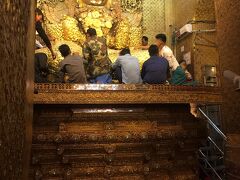 次にマハムニーパヤーを見学。
参拝者が寄付をして金箔をもらい、仏像に貼っているます。