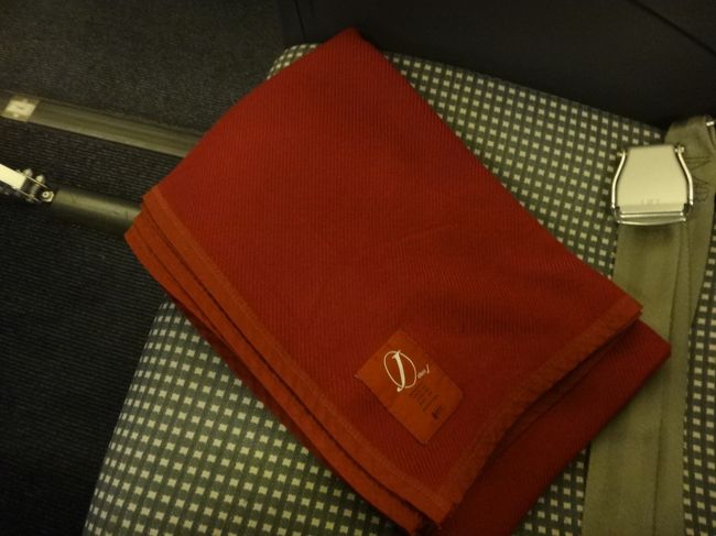 JAL 東京（羽田空港）6:40発 ― 石垣島（石垣空港）10:05着の日本航空の機内<br /><br />クラスJ専用のブランケットの写真。<br /><br />赤を基調としたヘッドレストカバーと同じカラーです。