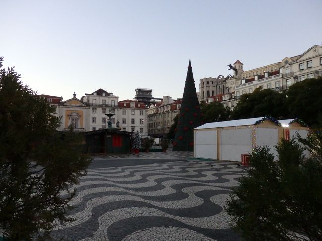 ロシオ広場の一角に、クリスマスマーケットの屋台がいくつかありました。<br />朝は営業していなので、ここも夕方来てみよう。<br />クリスマスは終わったけど、まだやっているのかな？<br /><br />波打ったモザイクが美しいね。